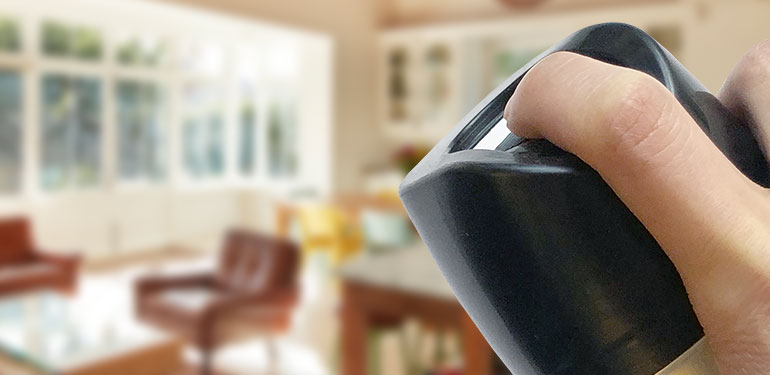 Hand of a person applying aerosol spray in a home.